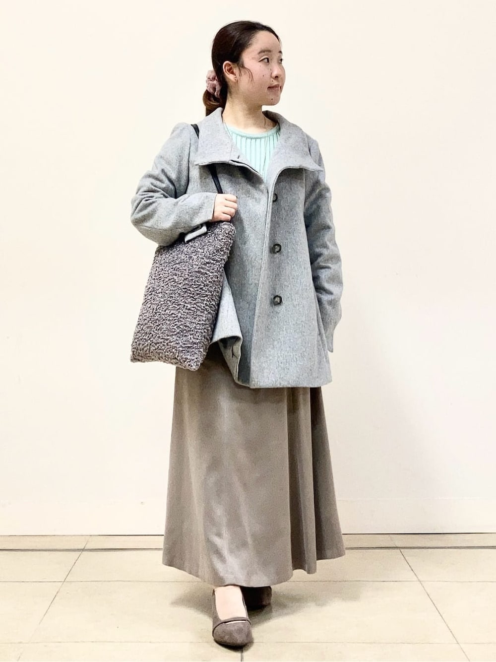 グレー系のその他アウター、グリーン系のニット/セーター、ベージュ系のスカートを着用したレディースの冬コーディネートの1枚目の写真