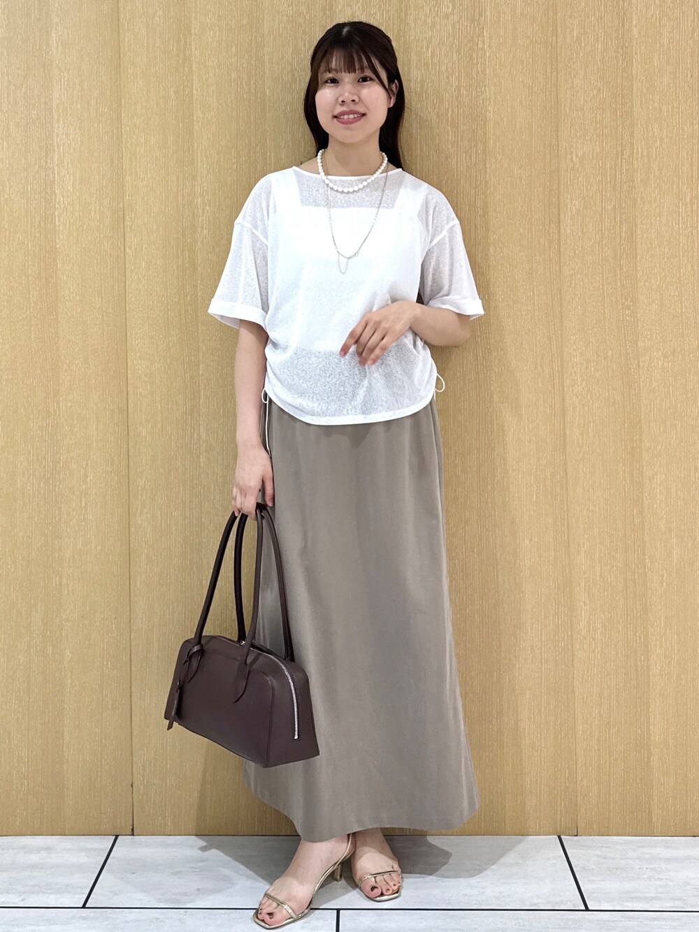 ホワイト系のTシャツ/カットソー、ホワイト系のタンクトップ、グリーン系のスカートを着用したレディースの夏コーディネートの1枚目の写真