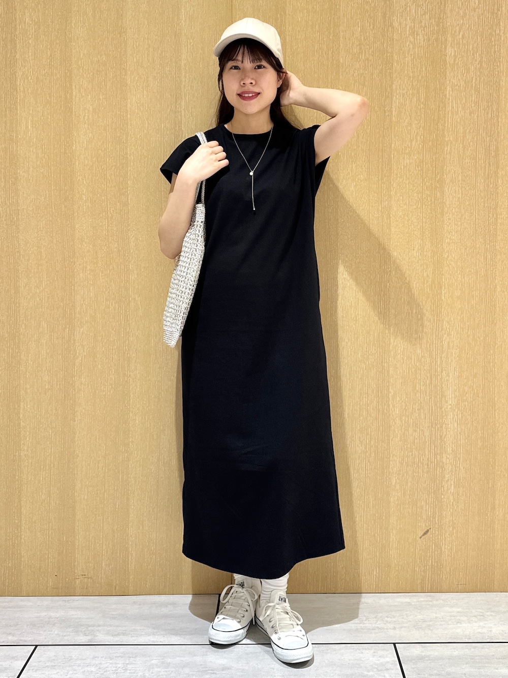 ブラック系のワンピース、ベージュ系のノーカラージャケットを着用したレディースの夏コーディネートの1枚目の写真