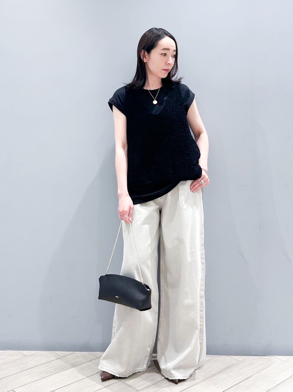 ブラック系のTシャツ/カットソー、ブラック系のタンクトップ、ブラック系のショルダーバッグを着用したレディースの春コーディネートの1枚目の写真
