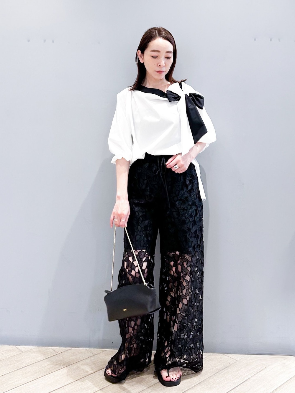 ブラック系のその他パンツ、ホワイト系のシャツ/ブラウス、ブラック系のショルダーバッグを着用したレディースの春コーディネートの1枚目の写真