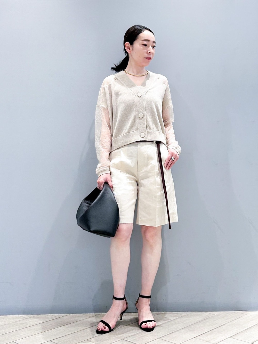 ベージュ系のその他パンツ、ベージュ系のカーディガン/ボレロ、ブラック系のハンドバッグを着用したレディースの春コーディネートの1枚目の写真