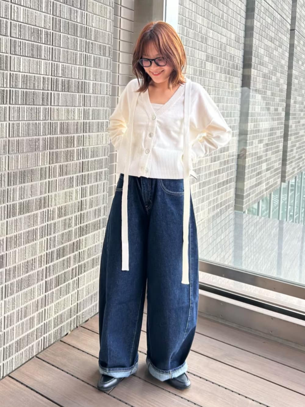 ホワイト系のカーディガン/ボレロ、ブルー系のデニムパンツを着用したレディースの冬コーディネートの1枚目の写真
