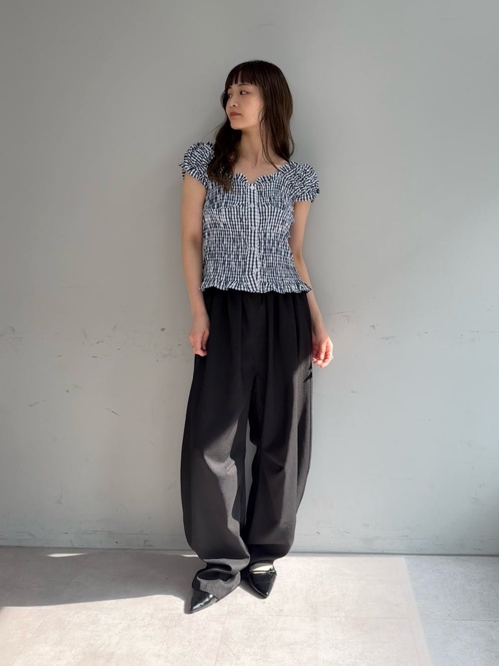 ブルー系のシャツ/ブラウス、ブラック系のスラックス、ブラック系のパンプスを着用したレディースの春コーディネートの1枚目の写真