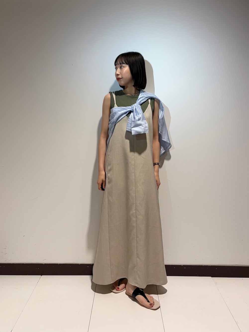 ベージュ系のワンピース、グリーン系のニット/セーター、ブルー系のシャツ/ブラウスを着用したレディースの夏コーディネートの1枚目の写真
