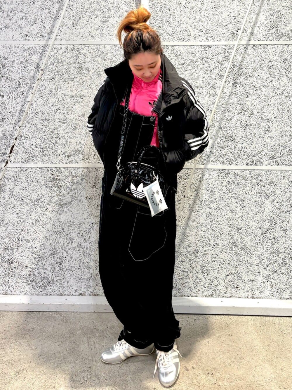 ブラック系のショルダーバッグ、ブラック系のダウンジャケット/コート、ピンク系のジャージを着用したレディースの秋コーディネートの1枚目の写真