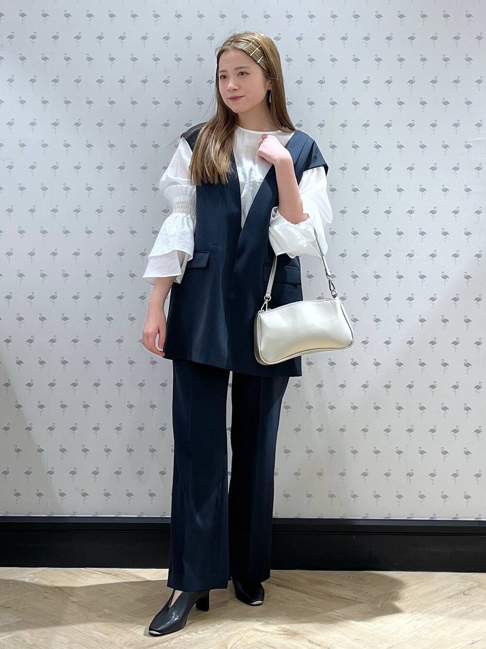 ブルー系のパンツドレス、シルバー系のショルダーバッグ、ブラック系のパンプスを着用したレディースの冬コーディネートの1枚目の写真