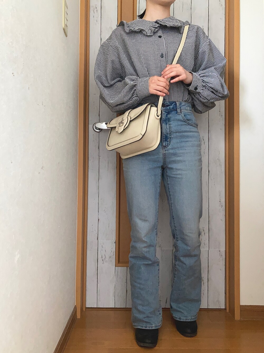 ブラック系のシャツ/ブラウス、ブルー系のデニムパンツ、ホワイト系のショルダーバッグを着用したレディースの春コーディネートの1枚目の写真