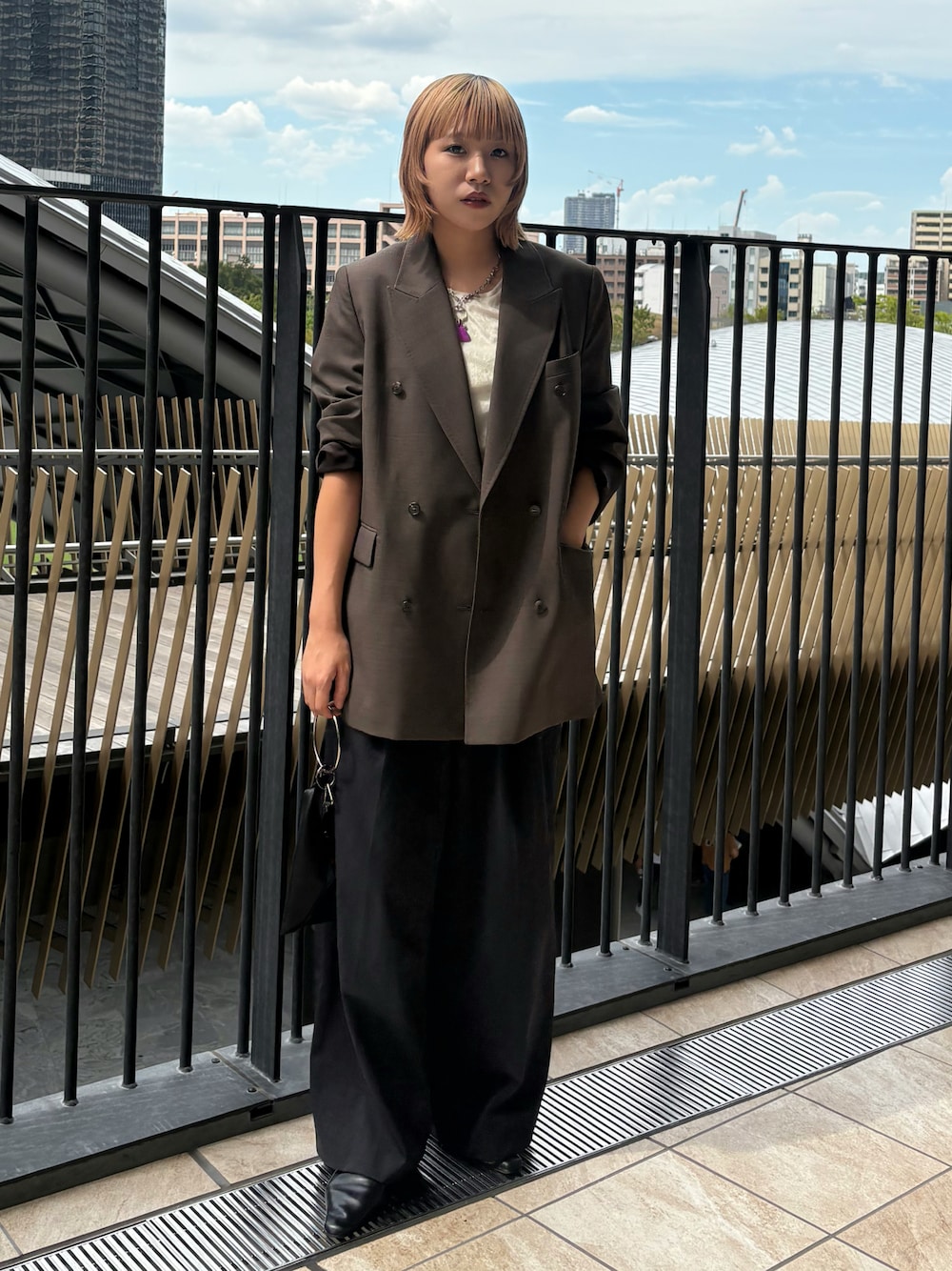 グレー系のテーラードジャケット、ホワイト系のTシャツ/カットソー、ブラック系のパンツを着用したレディースの秋コーディネートの1枚目の写真