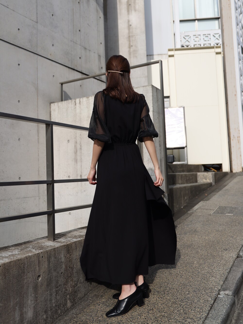 ブラック系のシューズ、ブラック系のワンピース、ゴールド系のバレッタ/ヘアクリップを着用したレディースの春コーディネートの1枚目の写真
