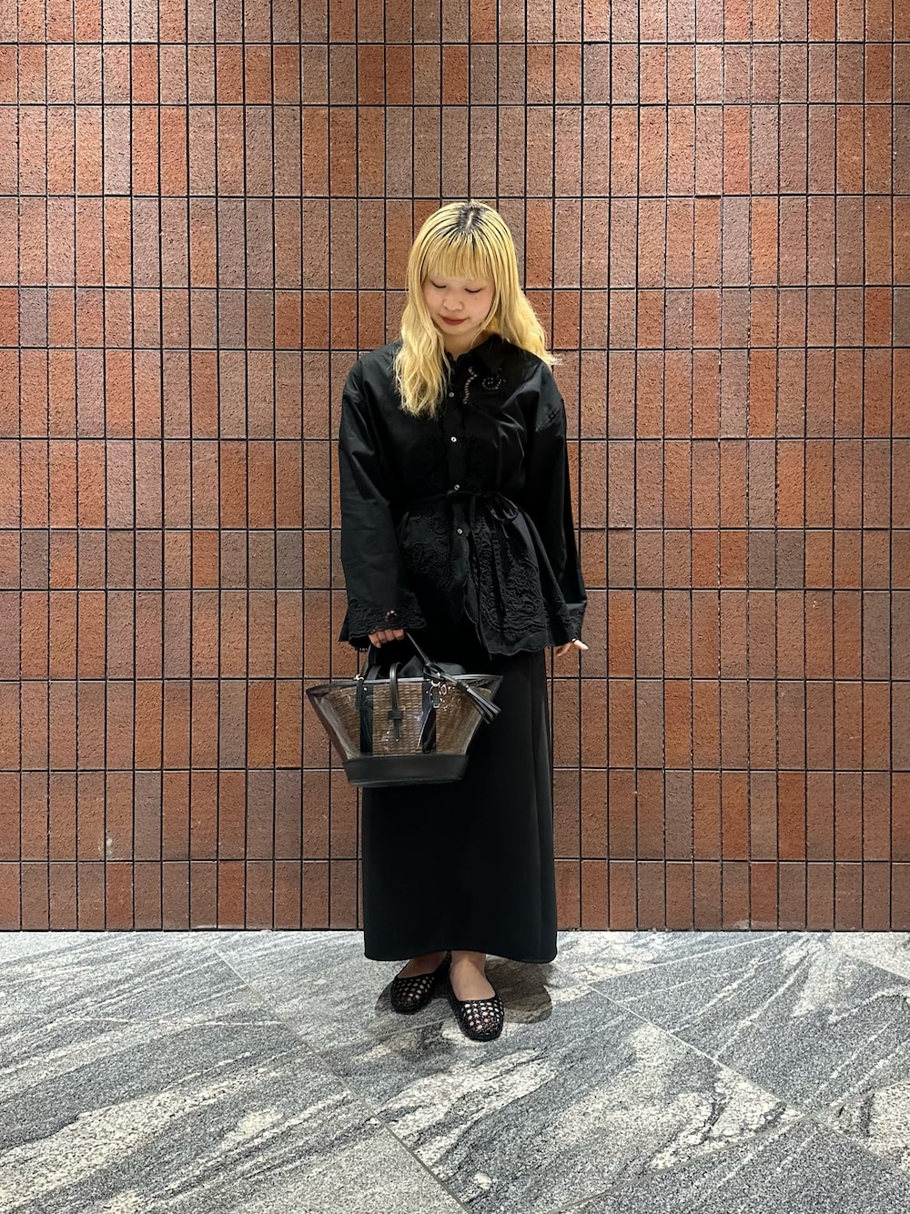 ブラック系のシャツ/ブラウス、ブラック系のサンダル、ブラック系のかごバッグを着用したレディースの春コーディネートの1枚目の写真