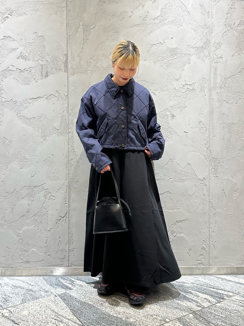 ブルー系のダウンジャケット/コート、ブラック系のワンピース、ブラック系のハンドバッグを着用したレディースの冬コーディネートの1枚目の写真