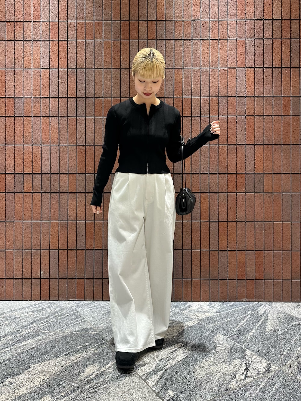 ブラック系のカーディガン/ボレロ、ホワイト系のデニムパンツ、ブラック系のショルダーバッグを着用したレディースの春コーディネートの1枚目の写真