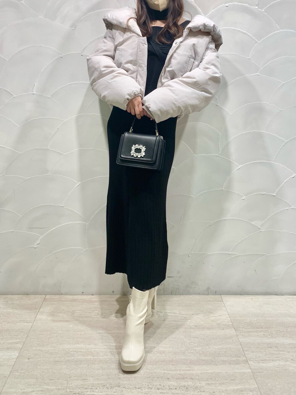 ホワイト系のダウンジャケット/コート、ブラック系のショルダーバッグ、ホワイト系のブーツを着用したレディースの冬コーディネートの1枚目の写真