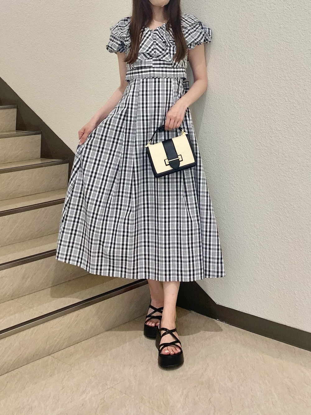 その他のワンピース、ブラック系のサンダル、ブラック系のハンドバッグを着用したレディースの夏コーディネートの1枚目の写真