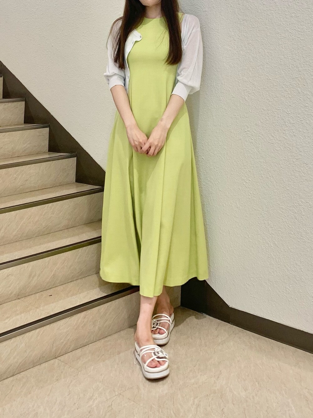 ホワイト系のカーディガン/ボレロ、グリーン系のワンピース、ホワイト系のサンダルを着用したレディースの春コーディネートの1枚目の写真