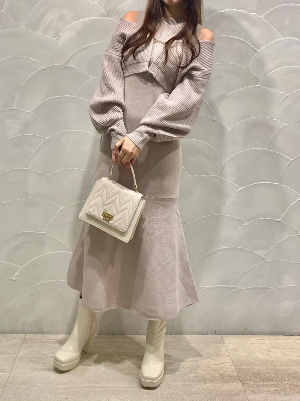 ピンク系のワンピース、ホワイト系のショルダーバッグ、ホワイト系のブーツを着用したレディースの秋コーディネートの1枚目の写真