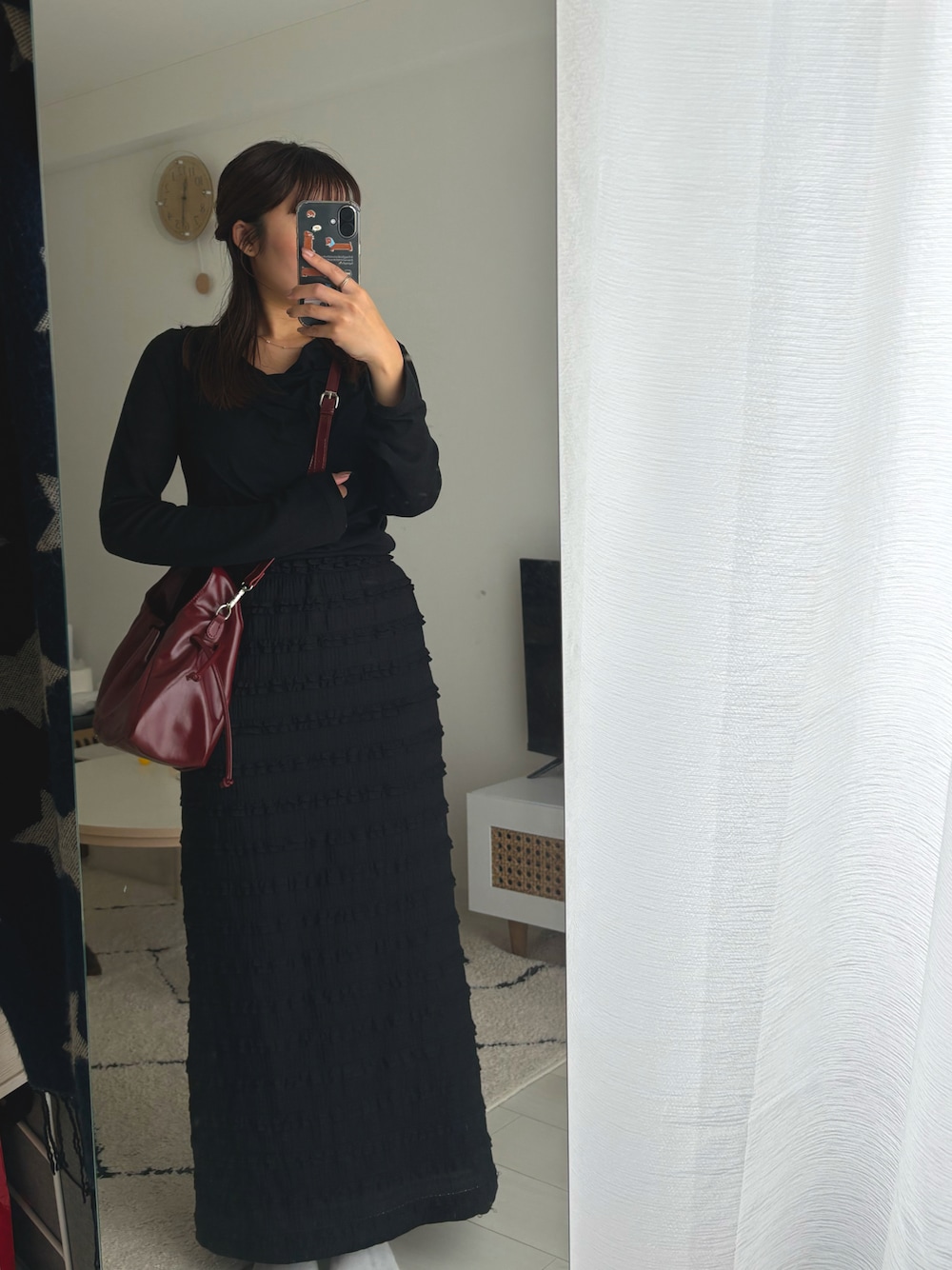 ブラック系のTシャツ/カットソー、ブラック系のスカート、レッド系のショルダーバッグを着用したレディースの秋コーディネートの1枚目の写真