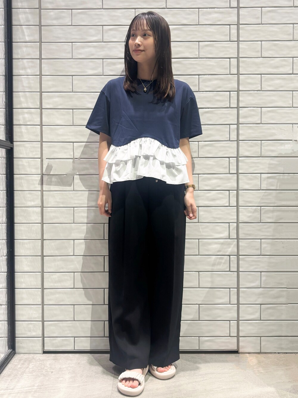 ブルー系のTシャツ/カットソー、ブラック系のその他パンツ、ホワイト系のサンダルを着用したレディースの春コーディネートの1枚目の写真