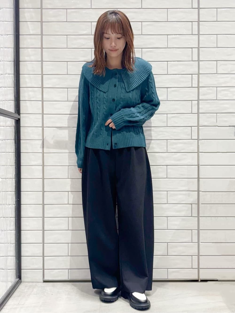 ブルー系のニット/セーター、ブラック系のその他パンツ、ブラック系のパンプスを着用したレディースの秋コーディネートの1枚目の写真