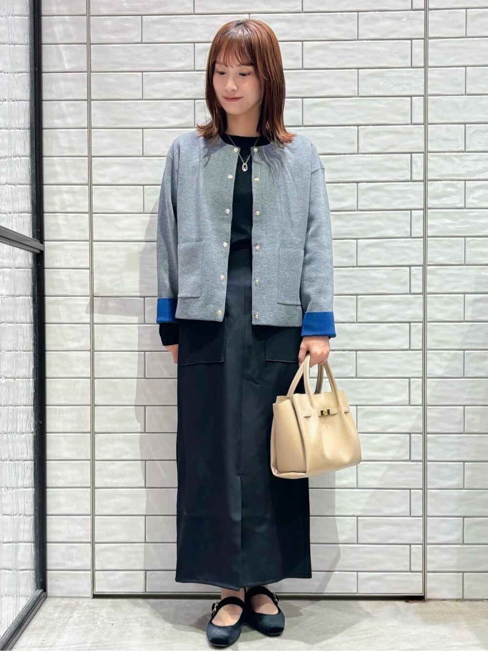 グレー系のカーディガン/ボレロ、ブラック系のTシャツ/カットソー、ブラック系のスカートを着用したレディースの秋コーディネートの1枚目の写真
