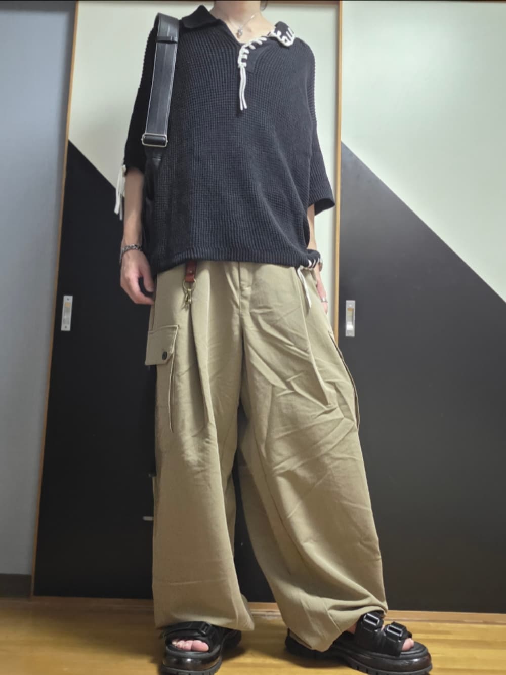 ブラック系のサンダル、ベージュ系のカーゴパンツ、グレー系のショルダーバッグを着用したメンズの夏コーディネートの1枚目の写真