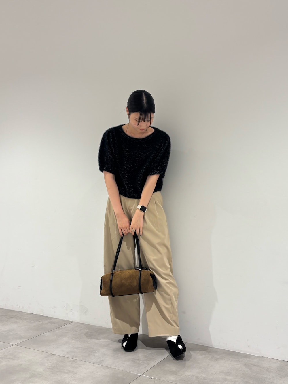 ブラック系のパンプス、ブラック系のニット/セーター、イエロー系のトートバッグを着用したレディースの秋コーディネートの1枚目の写真