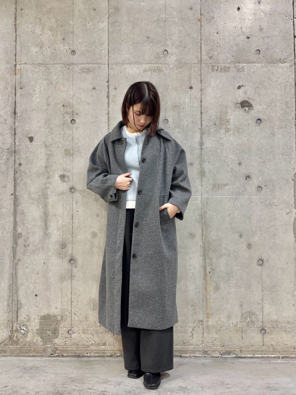 グレー系のその他パンツ、グレー系のステンカラーコート、ブルー系のニット/セーターを着用したレディースの冬コーディネートの1枚目の写真