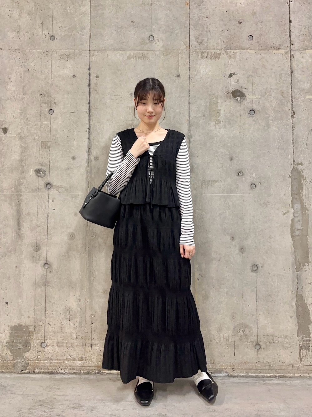ブラック系のセットアップ、ホワイト系のTシャツ/カットソー、ブラック系のショルダーバッグを着用したレディースの春コーディネートの1枚目の写真