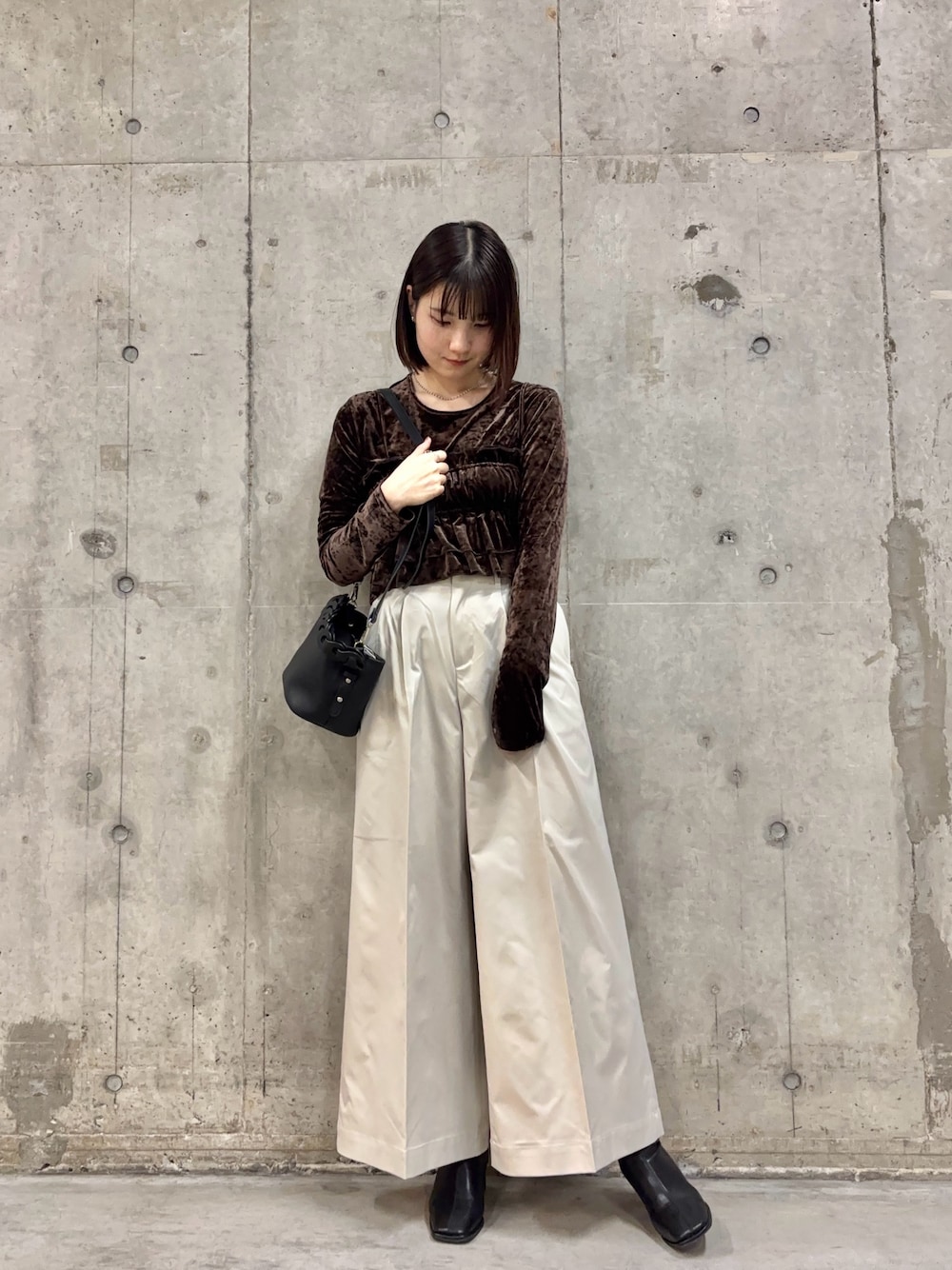 ブラック系のブーツ、ホワイト系のチノパンツ、ブラウン系のTシャツ/カットソーを着用したレディースの冬コーディネートの1枚目の写真