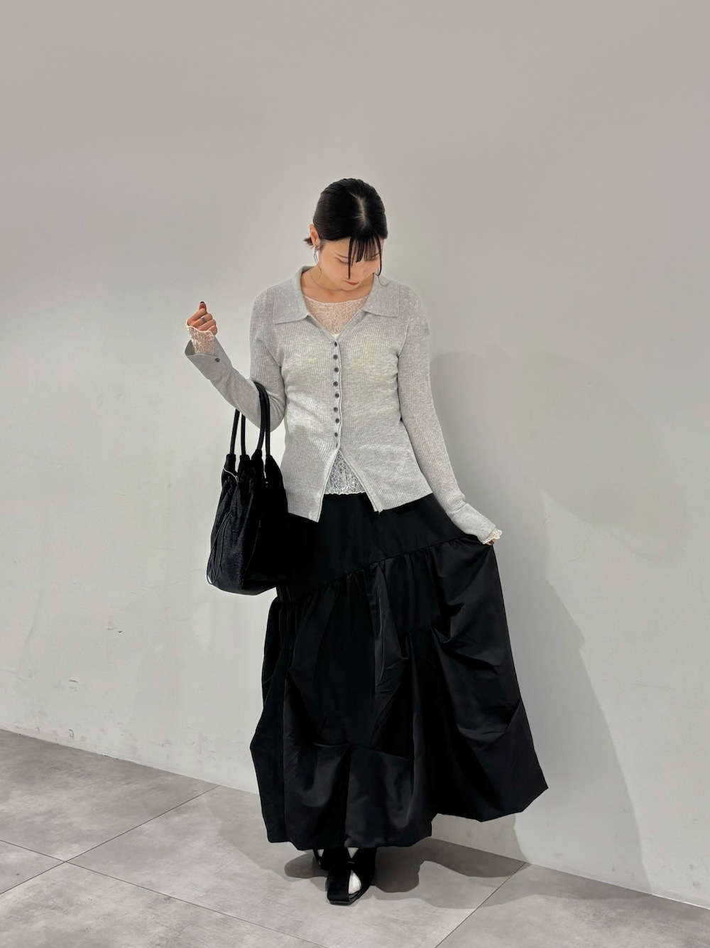 ホワイト系のTシャツ/カットソー、グレー系のカーディガン/ボレロ、ブラック系のスカートを着用したレディースの秋コーディネートの1枚目の写真