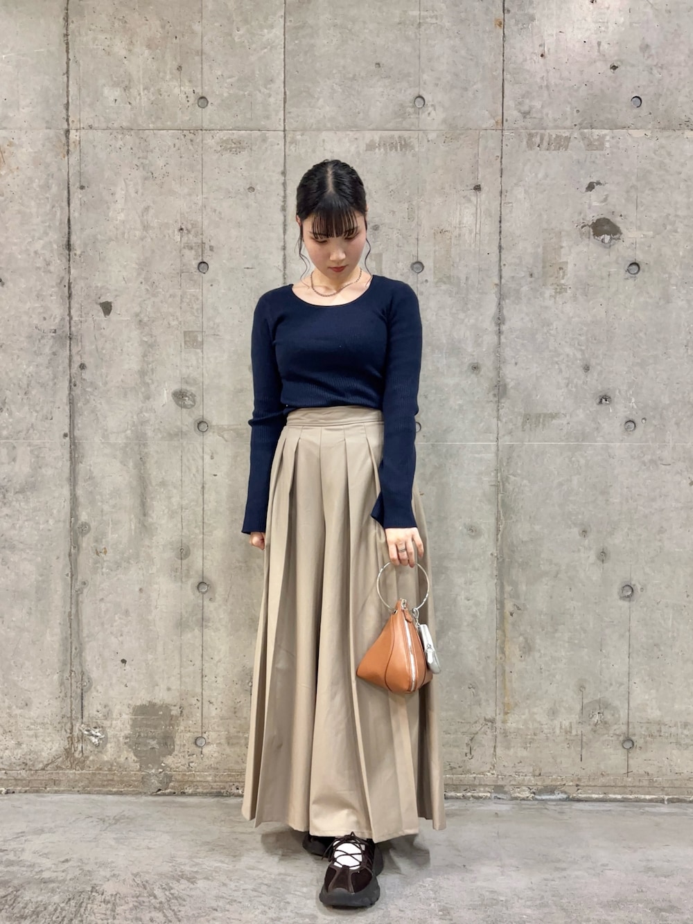 ブルー系のニット/セーター、ベージュ系のその他パンツ、イエロー系のハンドバッグを着用したレディースの秋コーディネートの1枚目の写真