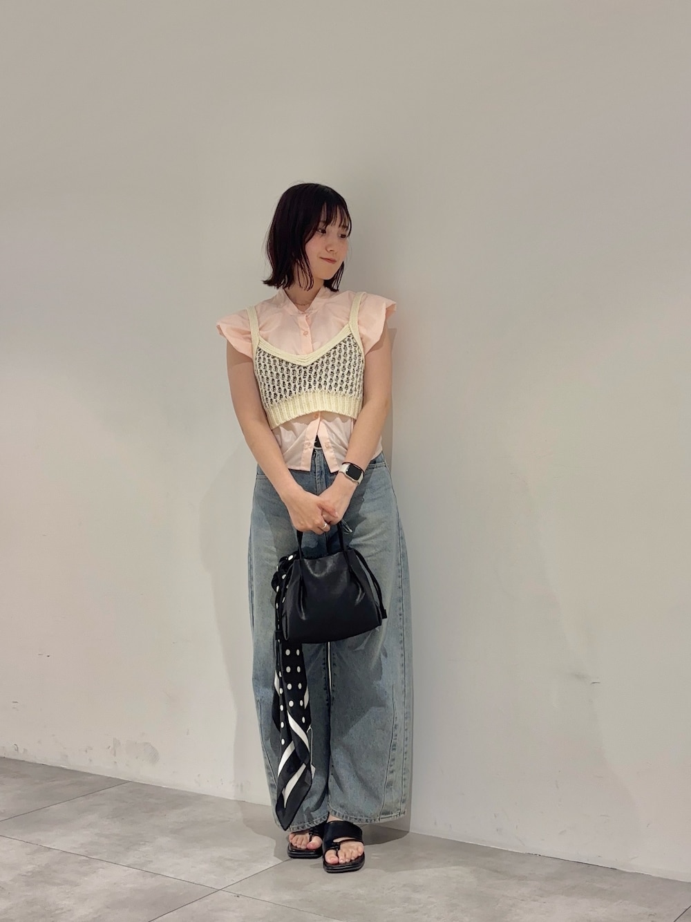 ブラック系のショルダーバッグ、ピンク系のシャツ/ブラウス、ホワイト系のニット/セーターを着用したレディースの夏コーディネートの1枚目の写真