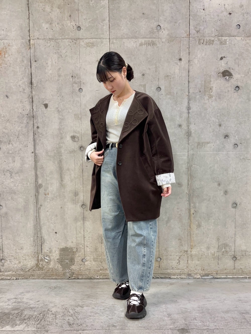 ホワイト系のニット/セーター、ブラウン系のその他アウター、ブルー系のデニムパンツを着用したレディースの秋コーディネートの1枚目の写真