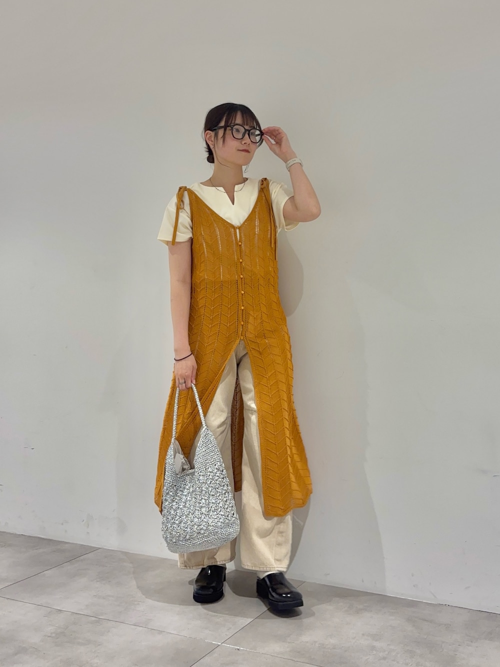 ホワイト系のTシャツ/カットソー、オレンジ系のワンピース、ベージュ系のデニムパンツを着用したレディースの春コーディネートの1枚目の写真