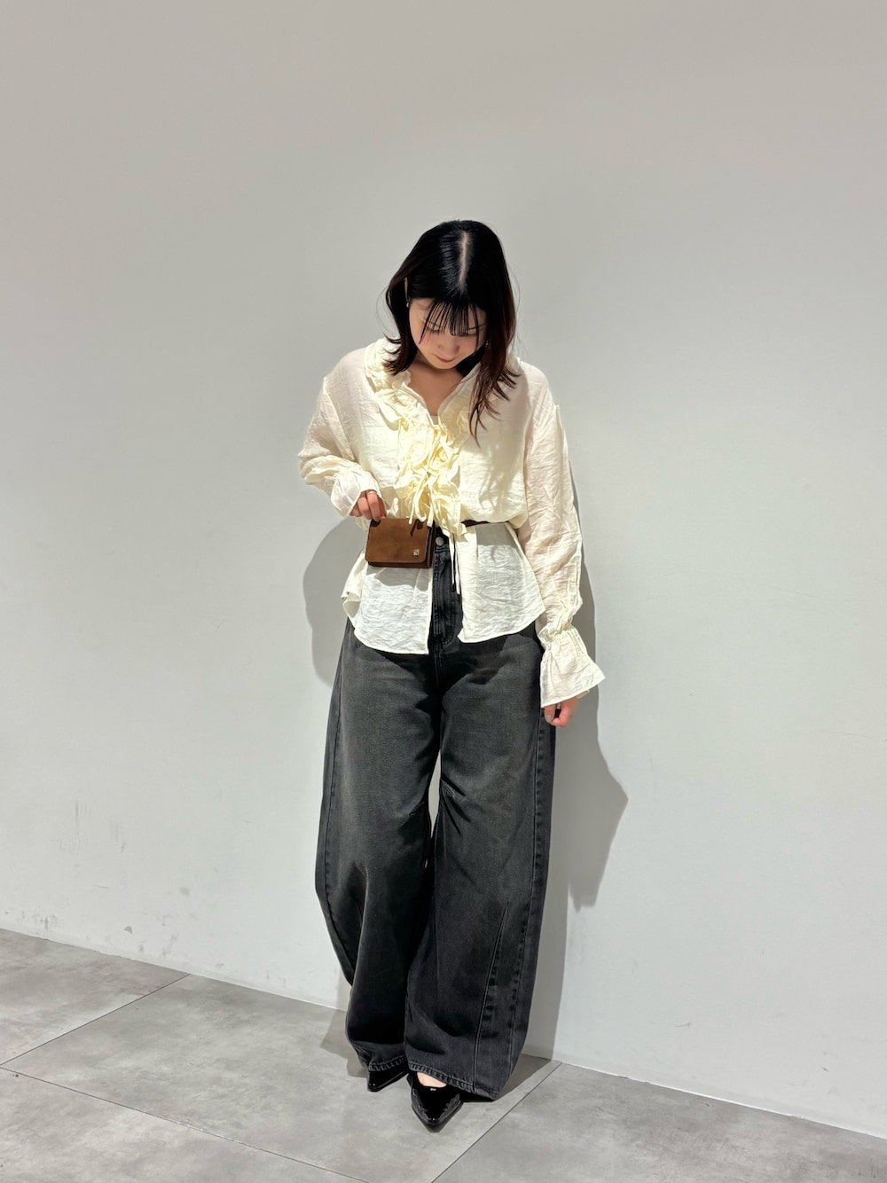 グレー系のデニムパンツ、ホワイト系のシャツ/ブラウス、ブラック系のパンプスを着用したレディースの秋コーディネートの1枚目の写真