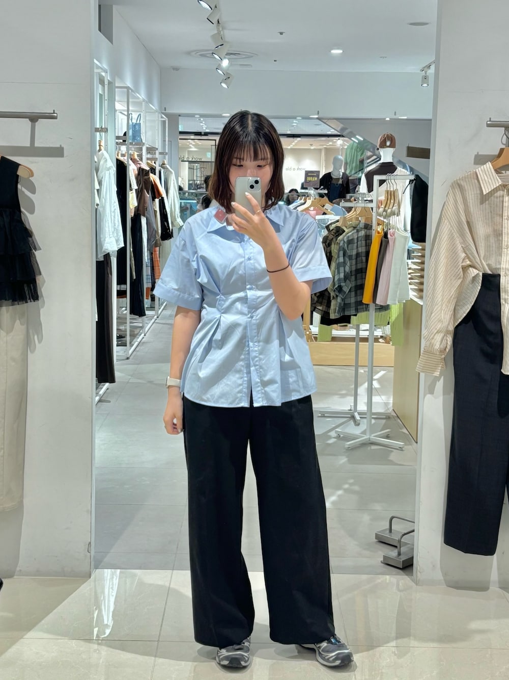 ブラック系のその他パンツ、ブルー系のシャツ/ブラウス、グレー系のスニーカーを着用したレディースの春コーディネートの1枚目の写真