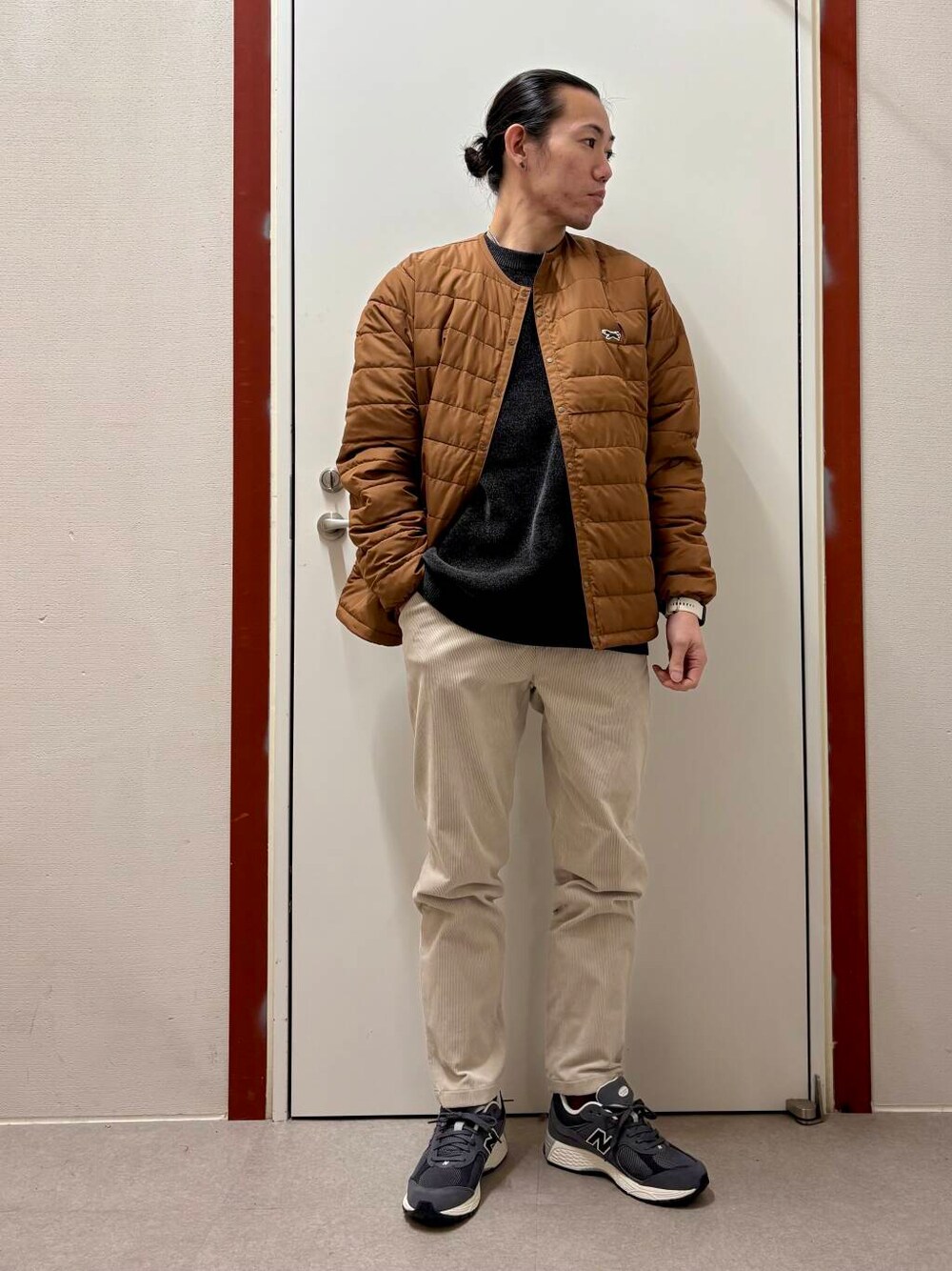ホワイト系のその他パンツ、グレー系のニット/セーター、オレンジ系のダウンジャケット/コートを着用したメンズの秋コーディネートの1枚目の写真
