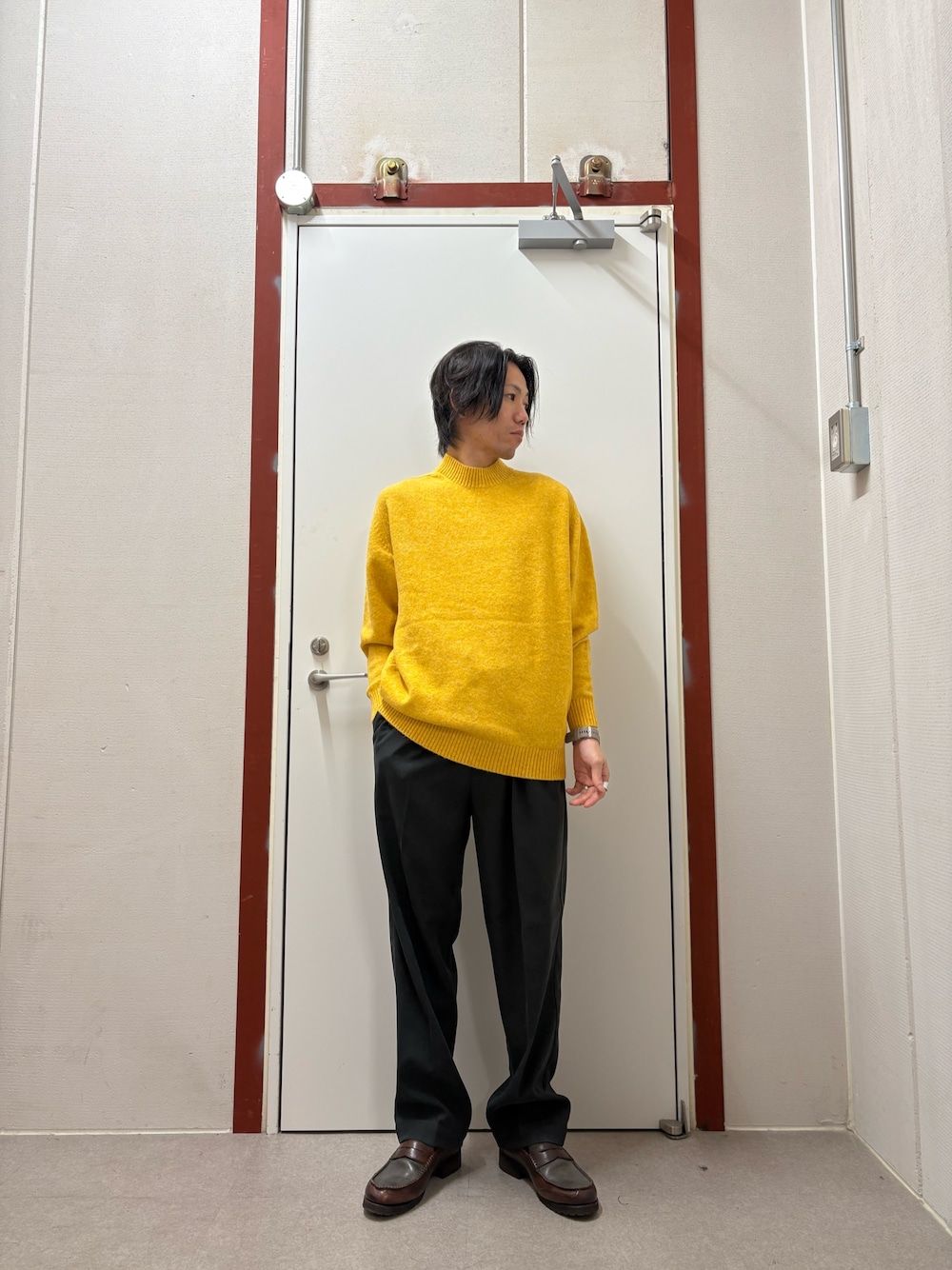 イエロー系のニット/セーター、ブラック系のその他パンツを着用したメンズの秋コーディネートの1枚目の写真