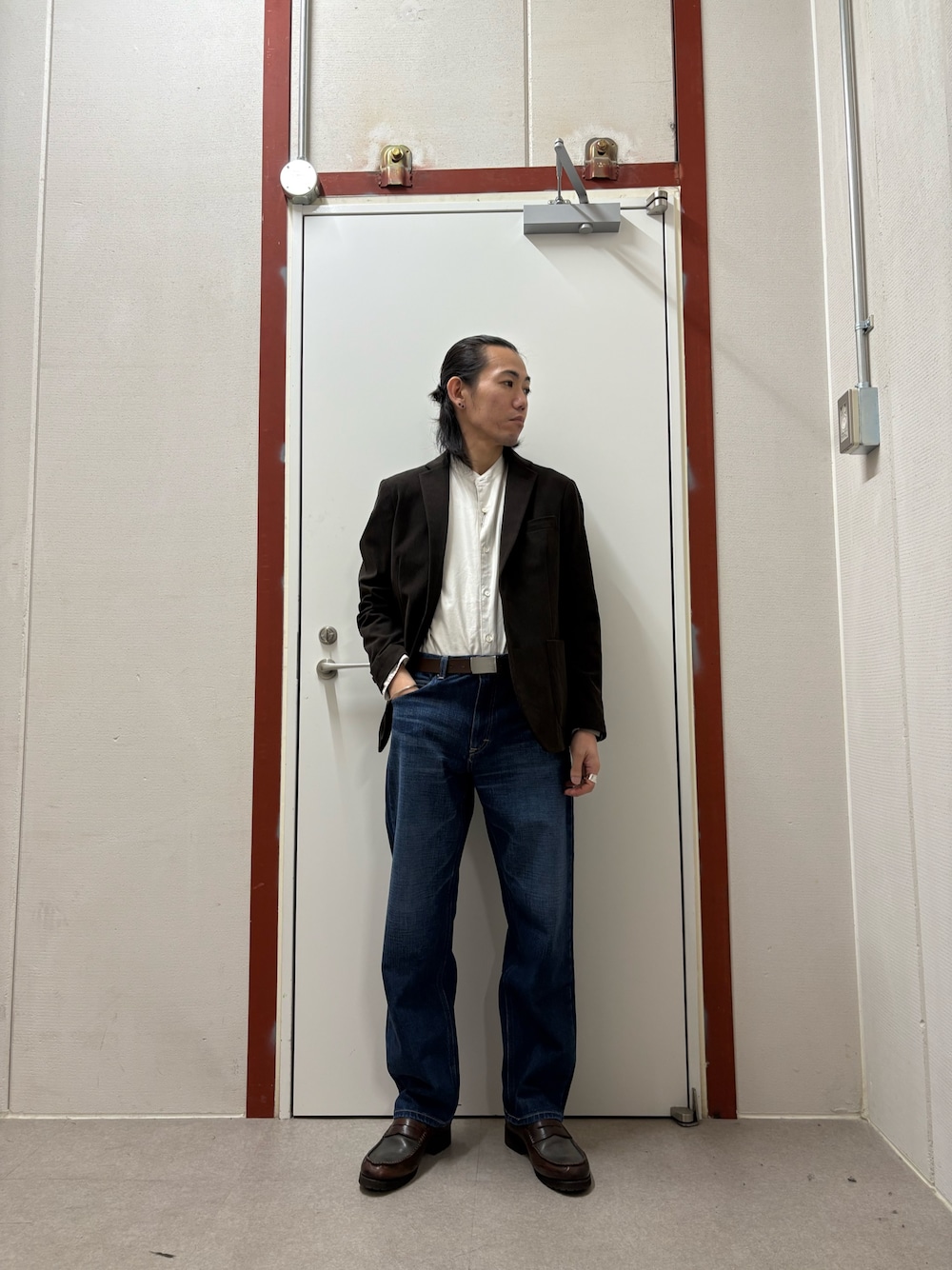 ブラウン系のスーツジャケット、ホワイト系のシャツ/ブラウス、ブルー系のデニムパンツを着用したメンズの秋コーディネートの1枚目の写真
