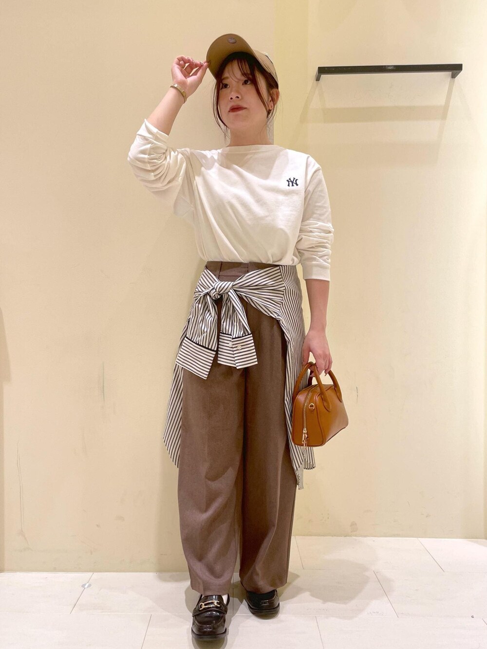 ホワイト系のシャツ/ブラウス、ホワイト系のTシャツ/カットソー、ベージュ系のスラックスを着用したレディースの秋コーディネートの1枚目の写真