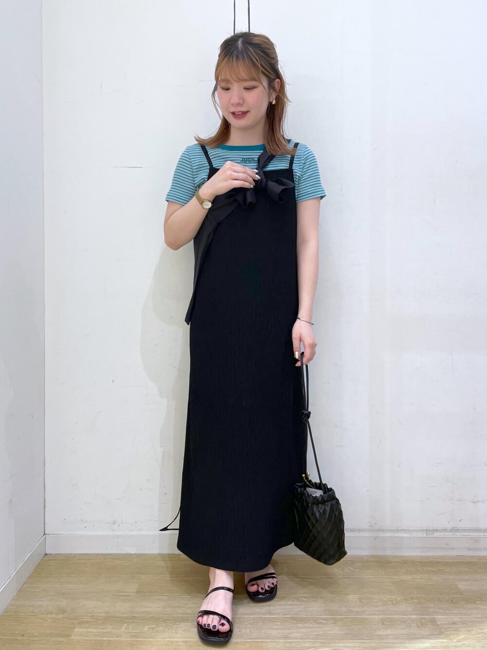 ブラック系のショルダーバッグ、ブラック系のサンダル、グリーン系のTシャツ/カットソーを着用したレディースの春コーディネートの1枚目の写真