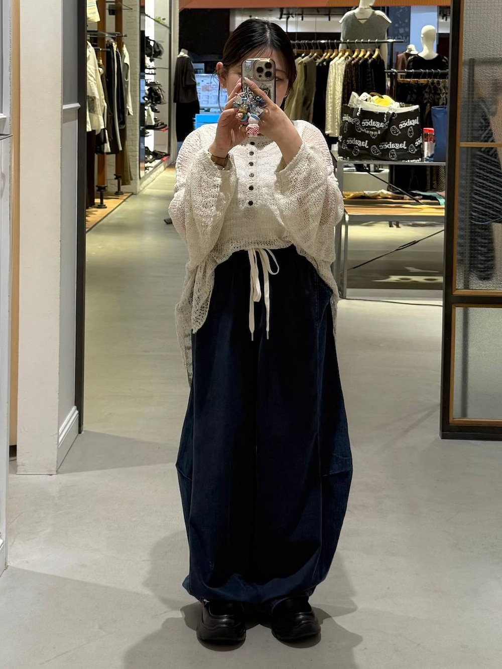 ブルー系のデニムパンツ、ブラック系のローファー、ホワイト系のニット/セーターを着用したレディースの夏コーディネートの1枚目の写真