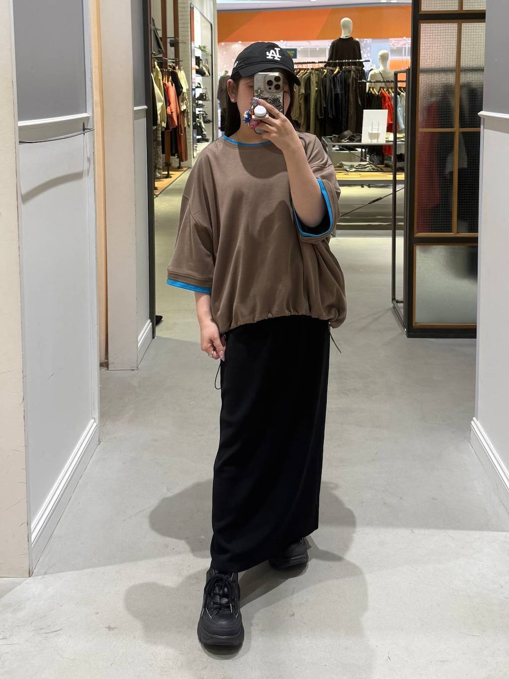 ブラック系のスカート、ブラウン系のTシャツ/カットソーを着用したレディースの春コーディネートの1枚目の写真
