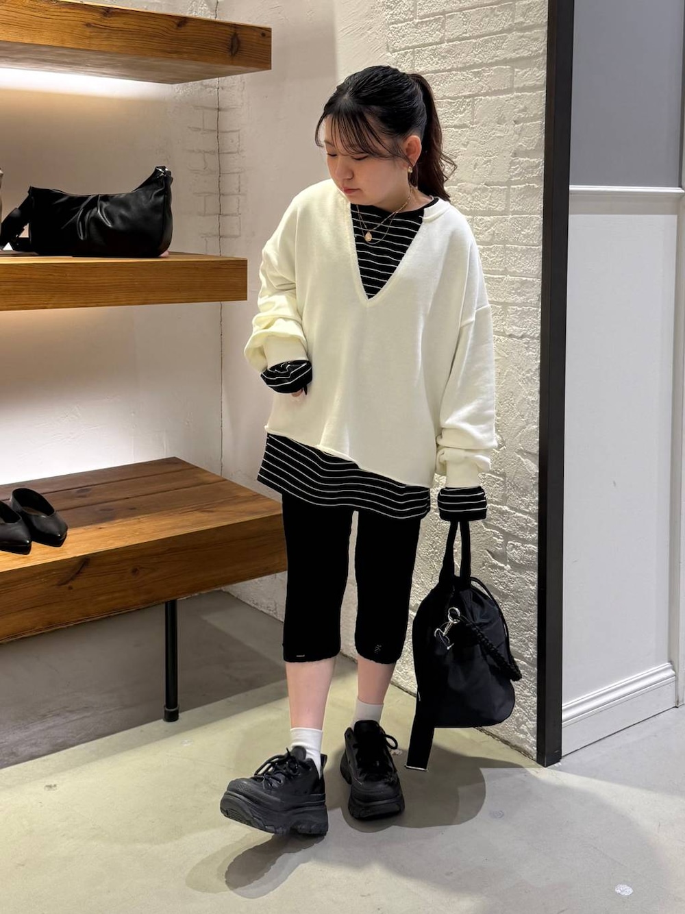 ブラック系のショルダーバッグ、ブラック系のTシャツ/カットソー、ブラック系のその他パンツを着用したレディースの冬コーディネートの1枚目の写真