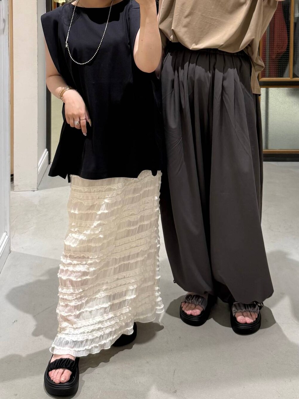 ベージュ系のTシャツ/カットソー、ブラック系のTシャツ/カットソー、ブラック系のサンダルを着用したレディースの夏コーディネートの1枚目の写真