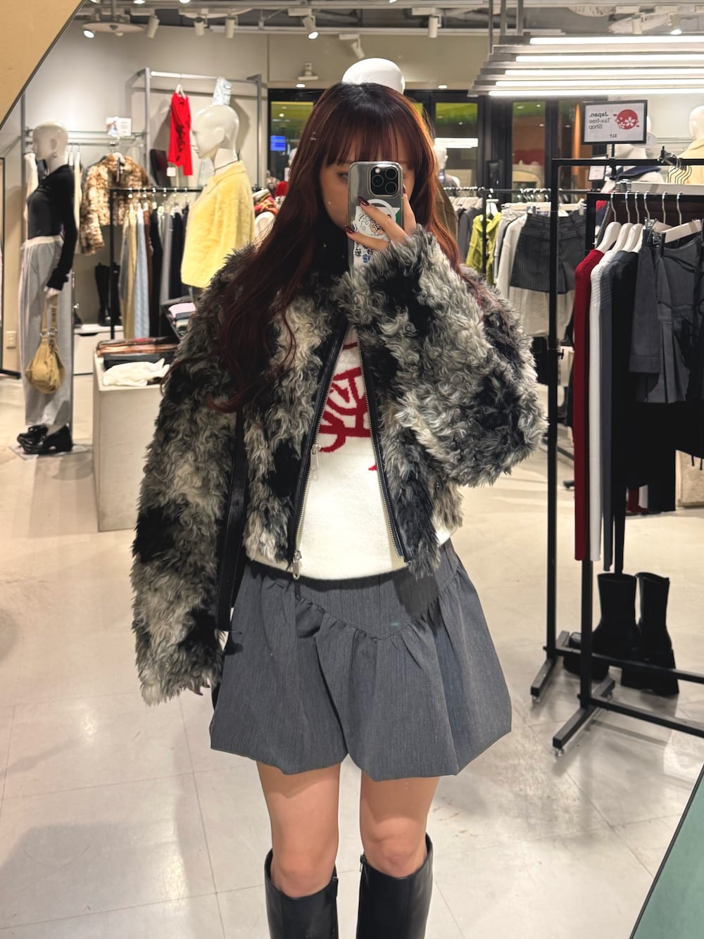 ブラック系のブルゾン、ホワイト系のニット/セーター、グレー系のスカートを着用したレディースの秋コーディネートの1枚目の写真