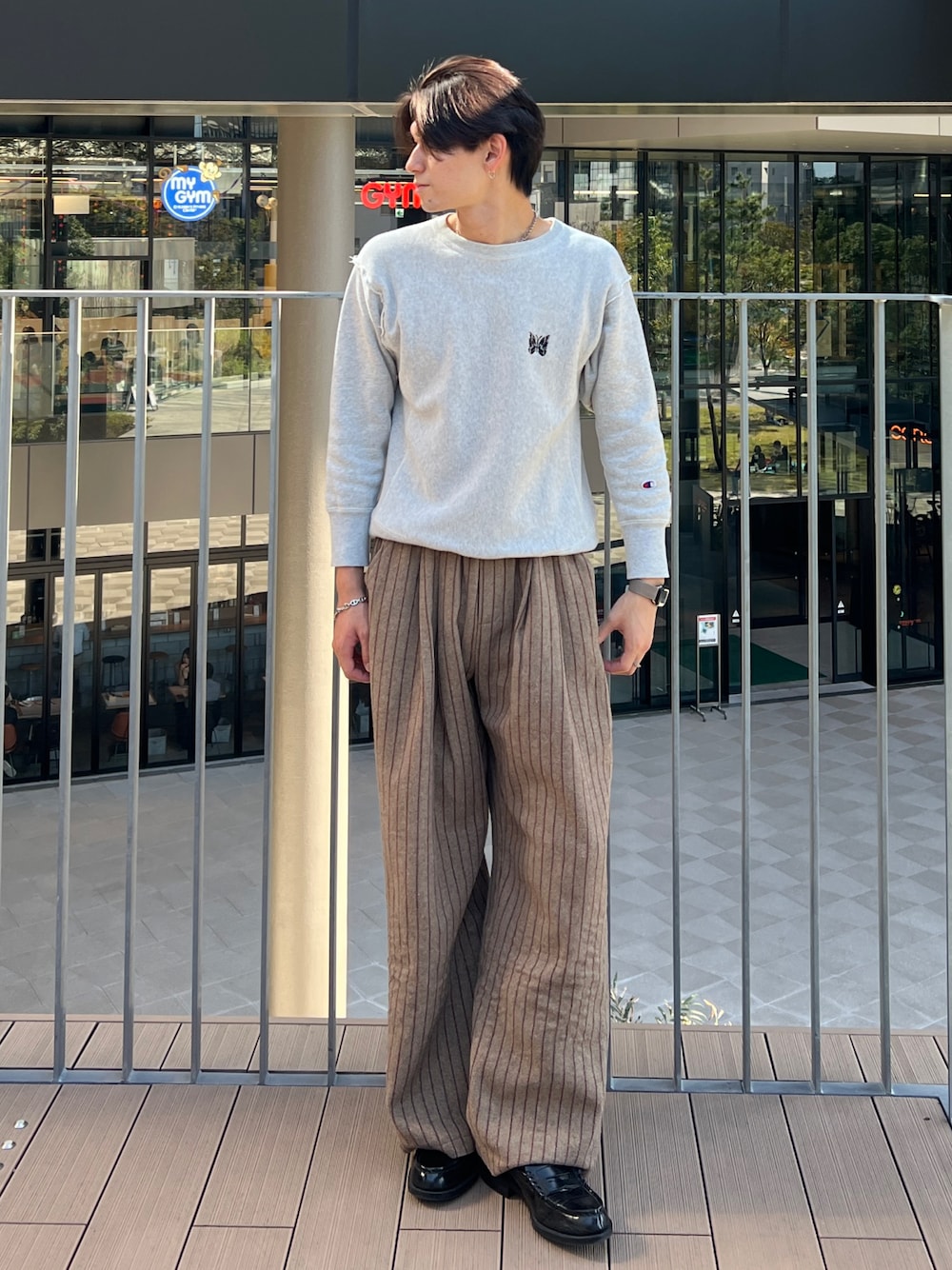 ブラック系のローファー、グレー系のスウェット、ブラウン系のパンツを着用したメンズの秋コーディネートの1枚目の写真