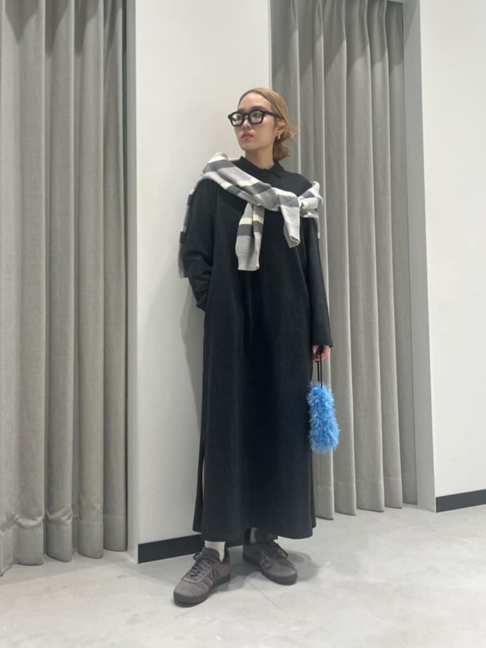 グレー系のワンピース、グレー系のニット/セーター、ブルー系のショルダーバッグを着用したレディースの春コーディネートの1枚目の写真