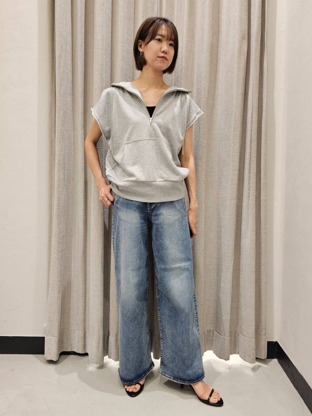 ブラック系のスリッポン、ブルー系のデニムパンツ、グレー系のパーカーを着用したレディースの夏コーディネートの1枚目の写真